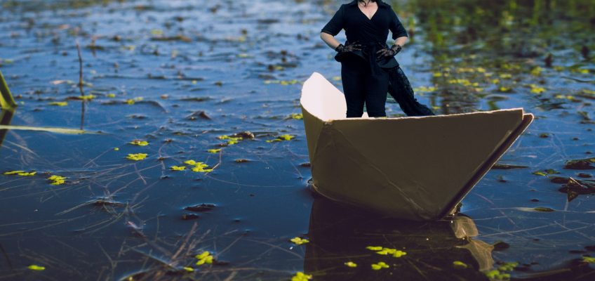 Laceface the cellist standing in a paper boat